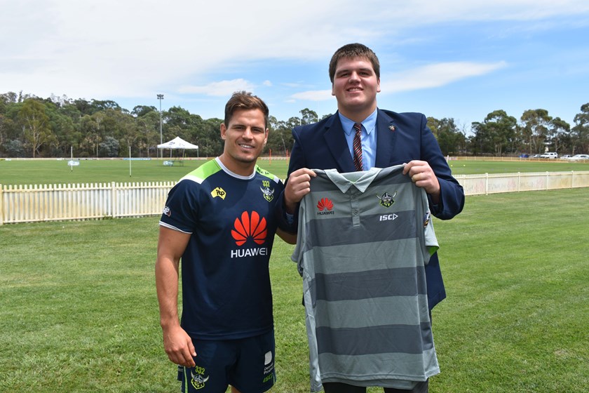 Aidan Sezer presents a Raiders Shirt for the upcoming Indigenous Youth Summit