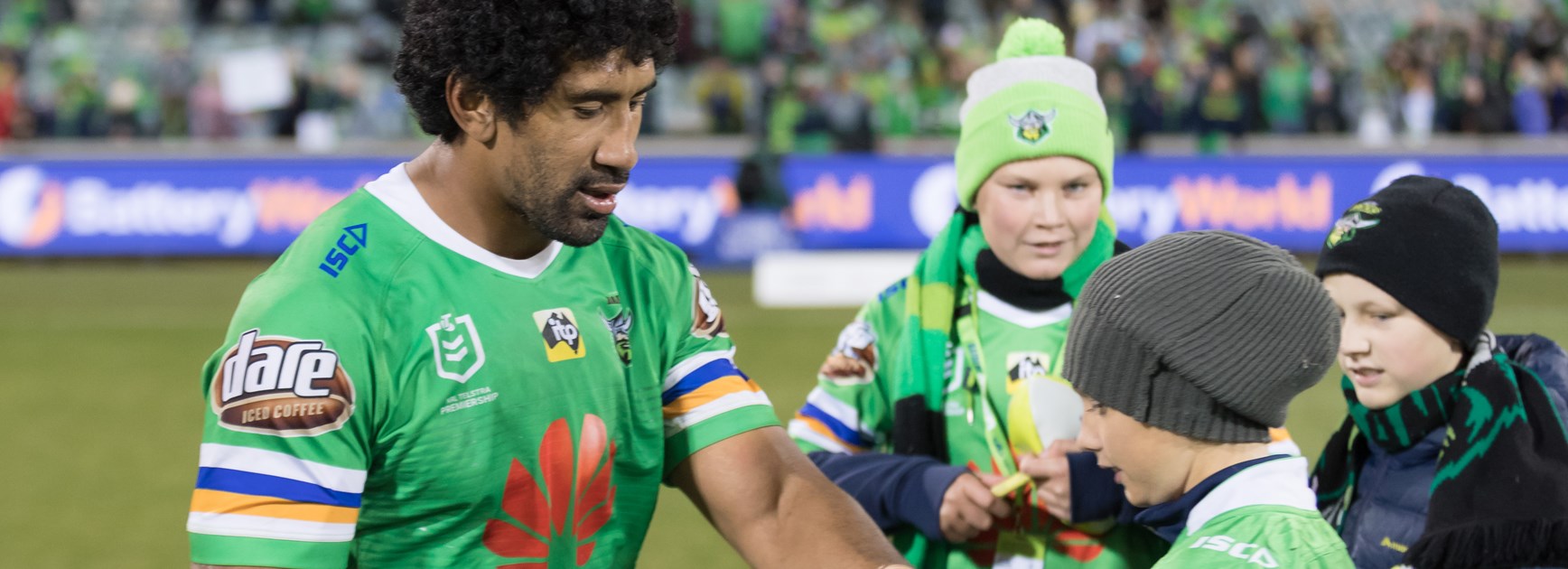 Sia Soliola signs and distributes mini footballs to young Raiders fans at a recent home game.