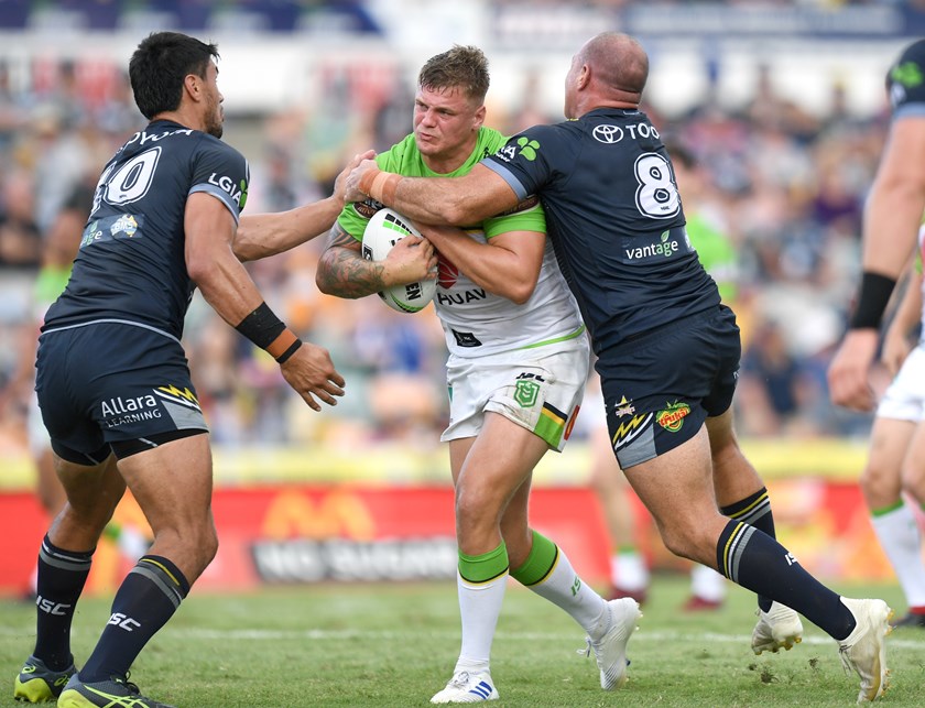 Sutton is tackled by Matt Scott and Jordan McLean of the North Queensland Cowboys. 